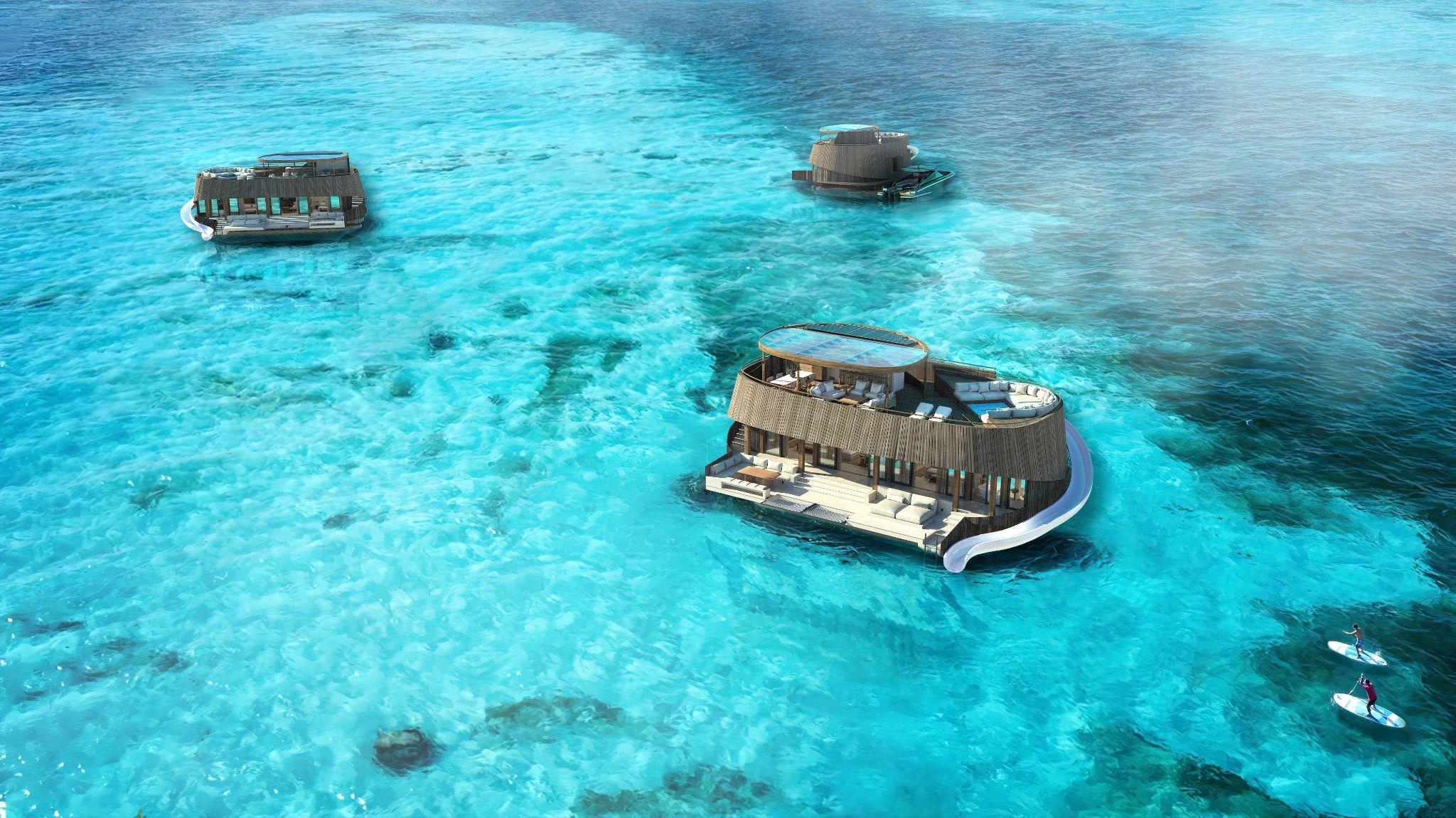 The Turtle Bungalow floating resort concept shown across a clear tropical lagoon
