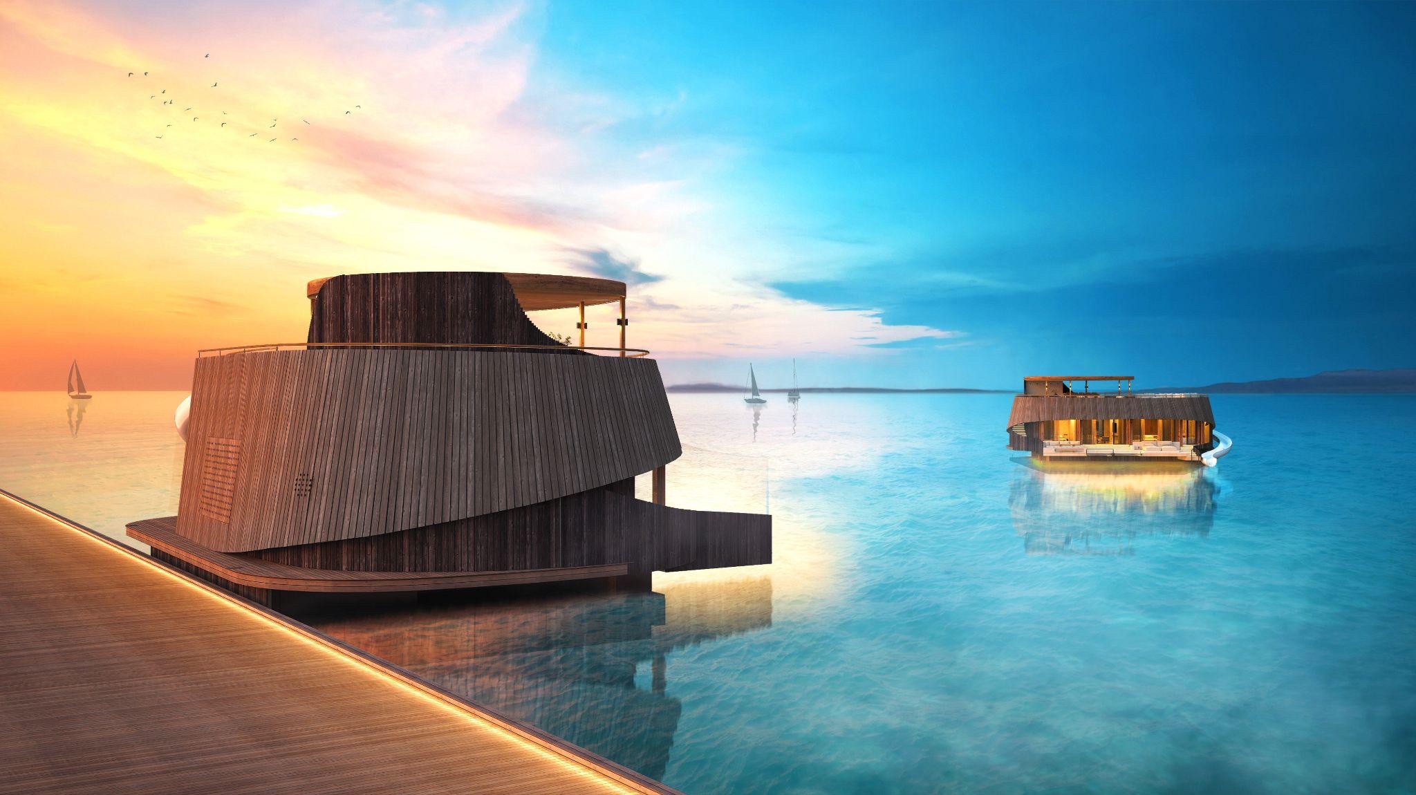 Turtle Bungalow units floating beside an island resort jetty at sunset